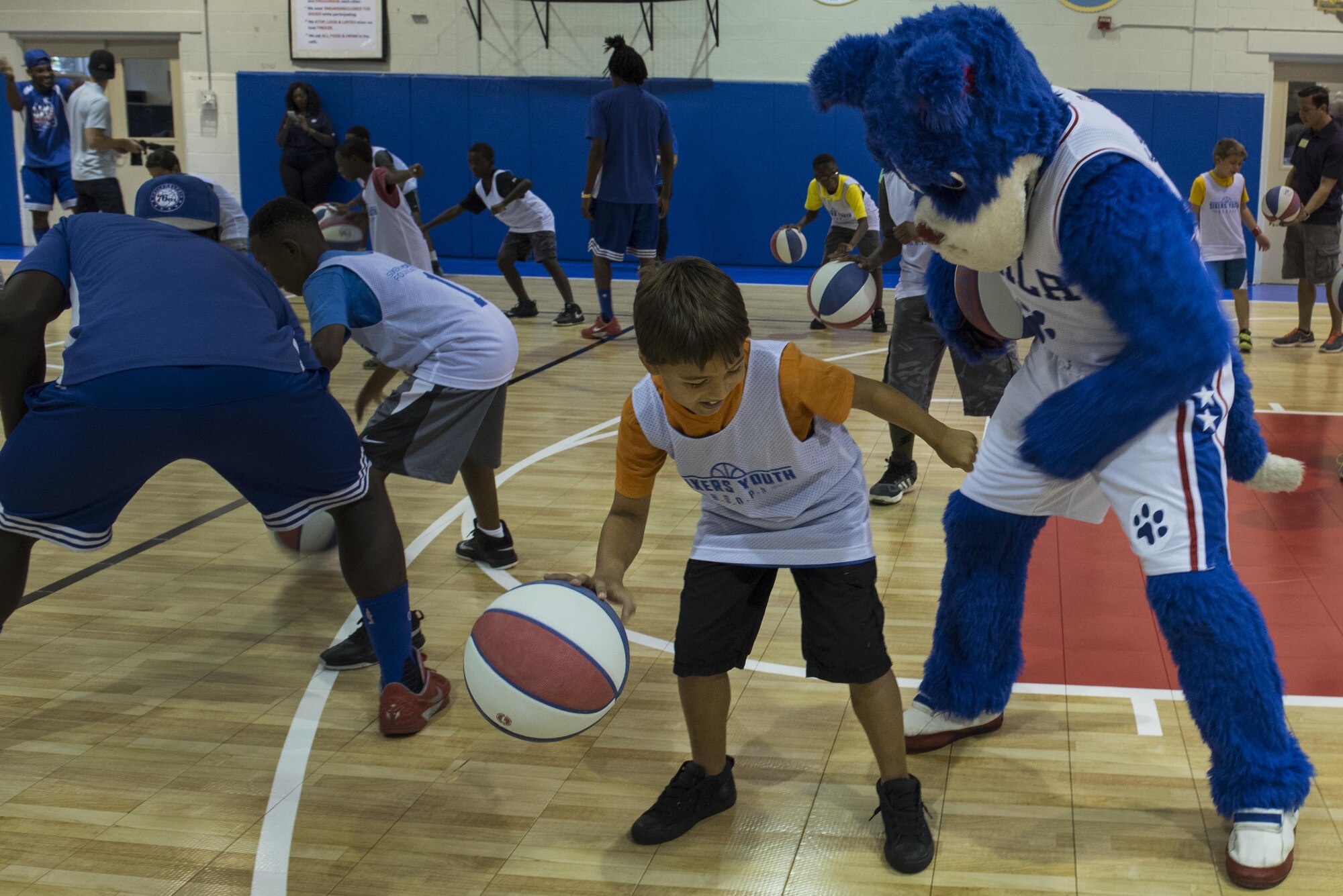 The 76ers’ mascot, Franklin the dog, practices basketball with the children of military families at Falcon Courts Youth Center Gym on Joint Base McGuire-Dix-Lakehurst, N.J., Aug. 31, 2016. Franklin and the 76ers’ trick shot team, Phlight Squad, entertained and coached children from military families at a youth basketball clinic. 