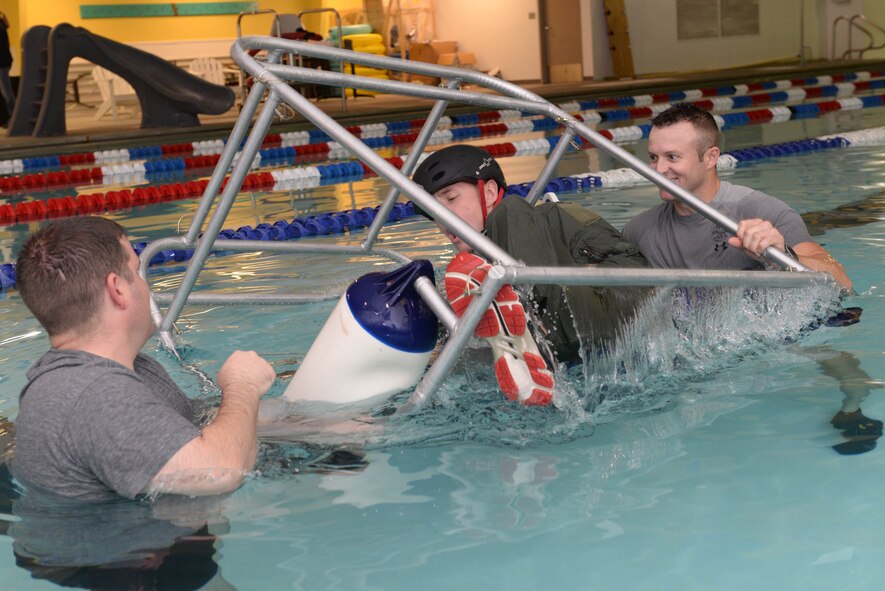 Capt. Mike Krysinski, a pilot assigned to the 54th Helicopter Squadron, takes a deep breath during survival, evasion, resistance and escape   underwater egress training at the McAdoo Fitness Center at Minot Air Force Base, N.D., Aug. 31, 2016. The SWET chair, or shallow water egress trainer, allows Airmen to practice escape procedures during a simulated helicopter crash. (U.S. Air Force photo/Airman 1st Class Jessica Weissman)