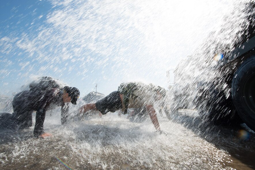 Participants of the GoRuck light training at Travis Air Force Base, Calif., get doused with water while doing pushups, Aug. 26, 2016. GoRuck light is a snapshot of the type of training that Special Operations Forces participate in and all proceeds benefit the Green Beret Foundation. (U.S. Air Force photo by Louis Briscese)