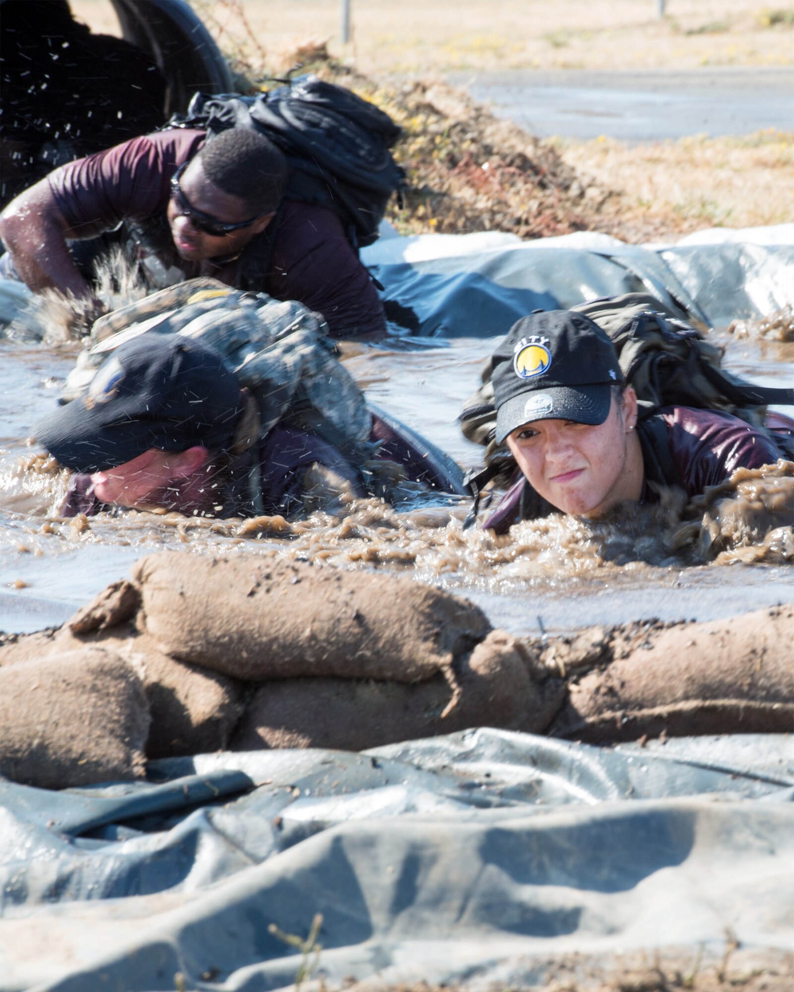 Participants of the GORUCK light training at Travis Air Force Base, Calif., maneuver through a water obstacle, Aug. 26, 2016. GORUCK light is a snapshot of the type of training that Special Operations Forces participate in and all proceeds benefit the Green Beret Foundation. (U.S. Air Force photo by Louis Briscese)