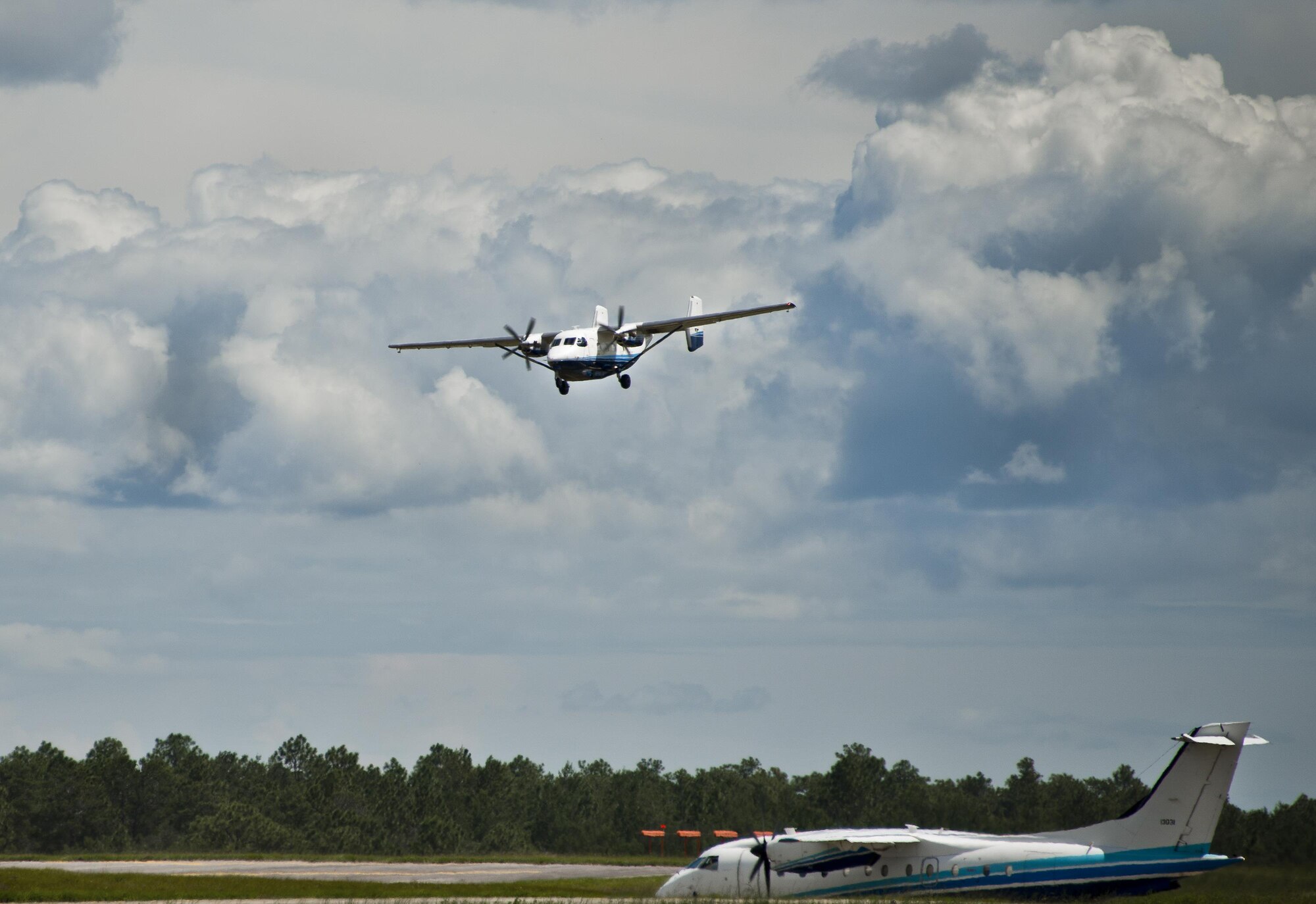 A C-145A Skytruck comes in for a landing as a C-146 Wolfhound waits to take off Aug. 31 at Duke Field, Fla.  The Skytruck is a special operations training aircraft and the Wolfhound is used in nonstandard aviation operations.  (U.S. Air Force photo/Tech. Sgt. Sam King)