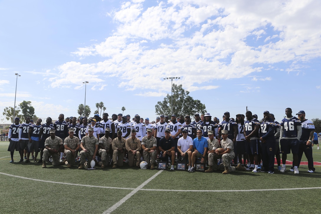 Col. Jason Woodworth, commanding officer of Marine Corps Air Station Miramar, and Marines pose for a photo with the San Diego Chargers during their visit aboard MCAS Miramar, Calif., Aug. 31. While aboard MCAS Miramar, the Chargers met service members and autographed various items for them. This event demonstrates the close ties between MCAS Miramar and the San Diego community.  (U.S. Marine Corps photo by Lance Cpl. Harley Robinson/Released)