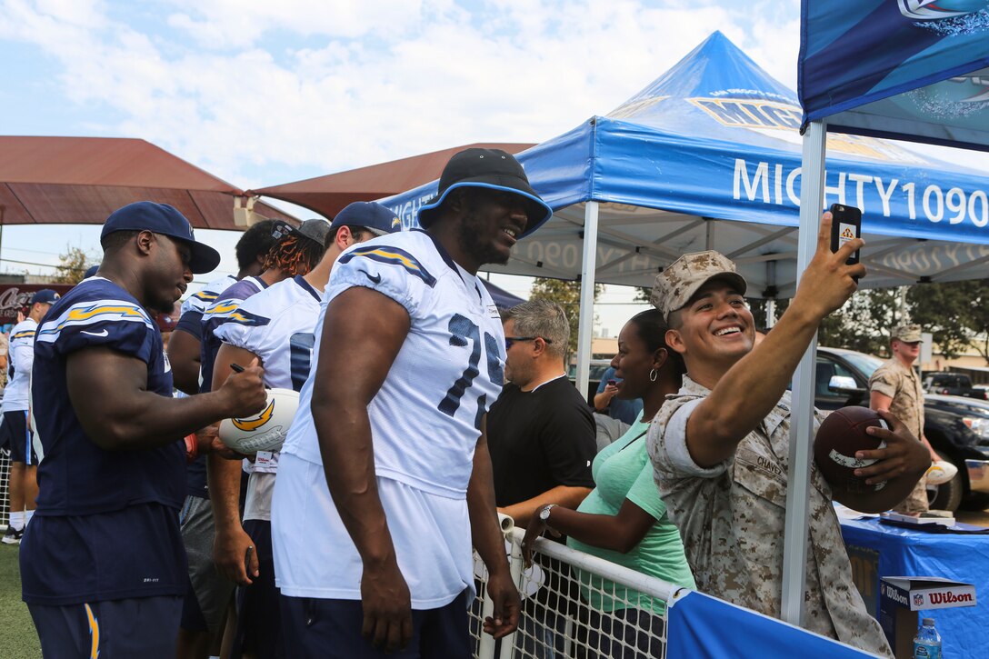 Chris Hairston, an offensive tackle for the San Diego Charger, takes a photo with a Marine at the Miramar Sports Complex during the Chargers visit aboard Marine Corps Air Station Miramar, Calif., Aug. 31. While aboard station, the Chargers met service members and autographed various items for them. This event demonstrates the close ties between MCAS Miramar and the San Diego community.  (U.S. Marine Corps photo by Lance Cpl. Harley Robinson/Released)