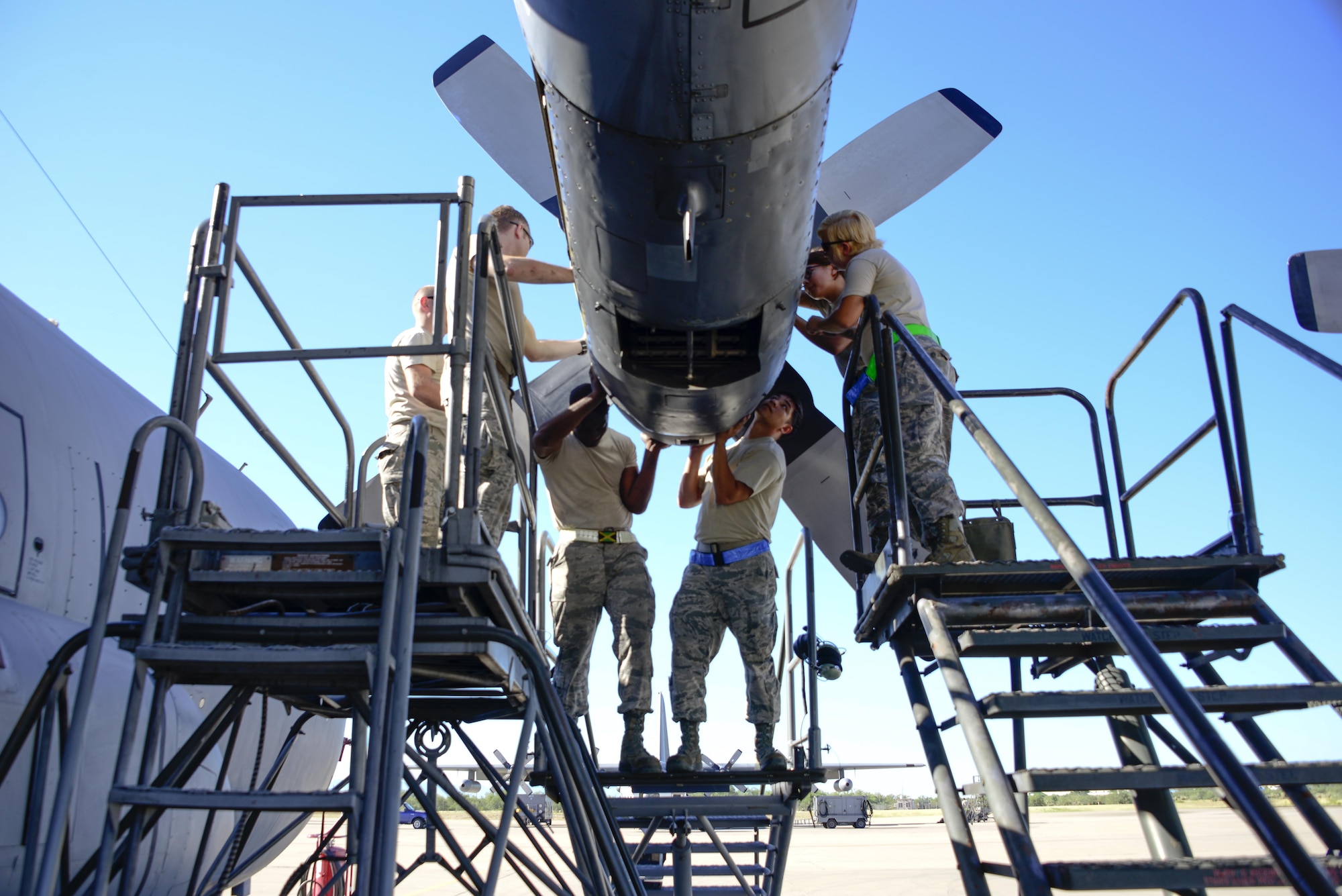 U.S. Airmen from the 755th Aircraft Maintenance Squadron install a new chin scoop on an EC-130H Compass Call at Davis-Monthan Air Force Base, Ariz., Aug. 31, 2016. The chin scoop aids in getting air to the engines compressor. (U.S. Air Force photo by Senior Airman Betty R. Chevalier)