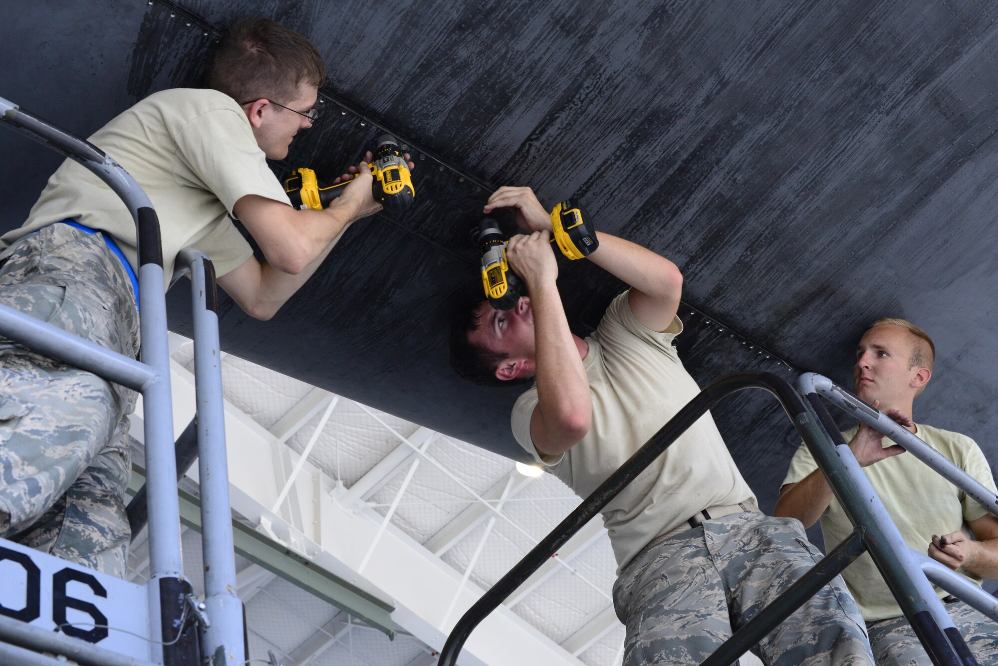 U.S. Airmen from the 755th Aircraft Maintenance Squadron remove screws from a panel on a horizontal stabilizer of an EC-130H Compass Call at Davis-Monthan Air Force Base, Ariz., Aug. 30, 2016. The 755th AMXS provides combatant commanders with combat ready EC-130H Compass Call aircraft to expeditiously execute information warfare and electronic attack operations. (U.S. Air Force photo by Senior Airman Betty R. Chevalier)