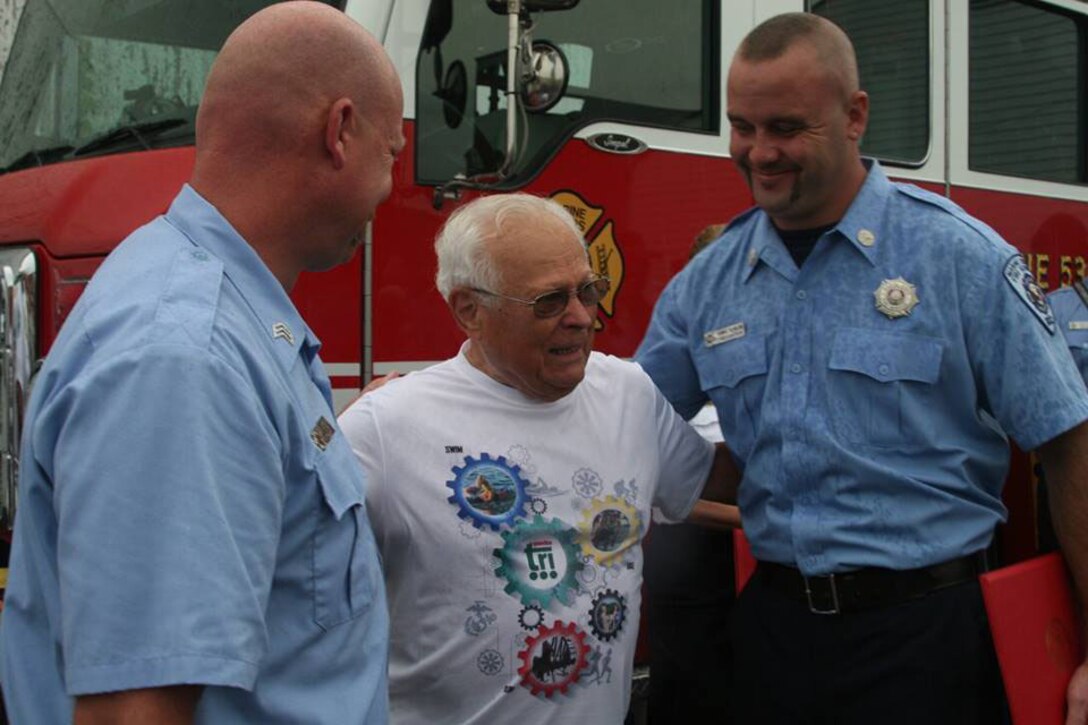 Sergeant Steven Denton (L) and Fireman Thomas Seabold (R) flank Thomas Tobias, the man they revived from drowning during the Quantico Triathlon. Denton and Seabold received commendations for their rescue effort and Tobias was in attendance with his wife and daughter at the ceremony.