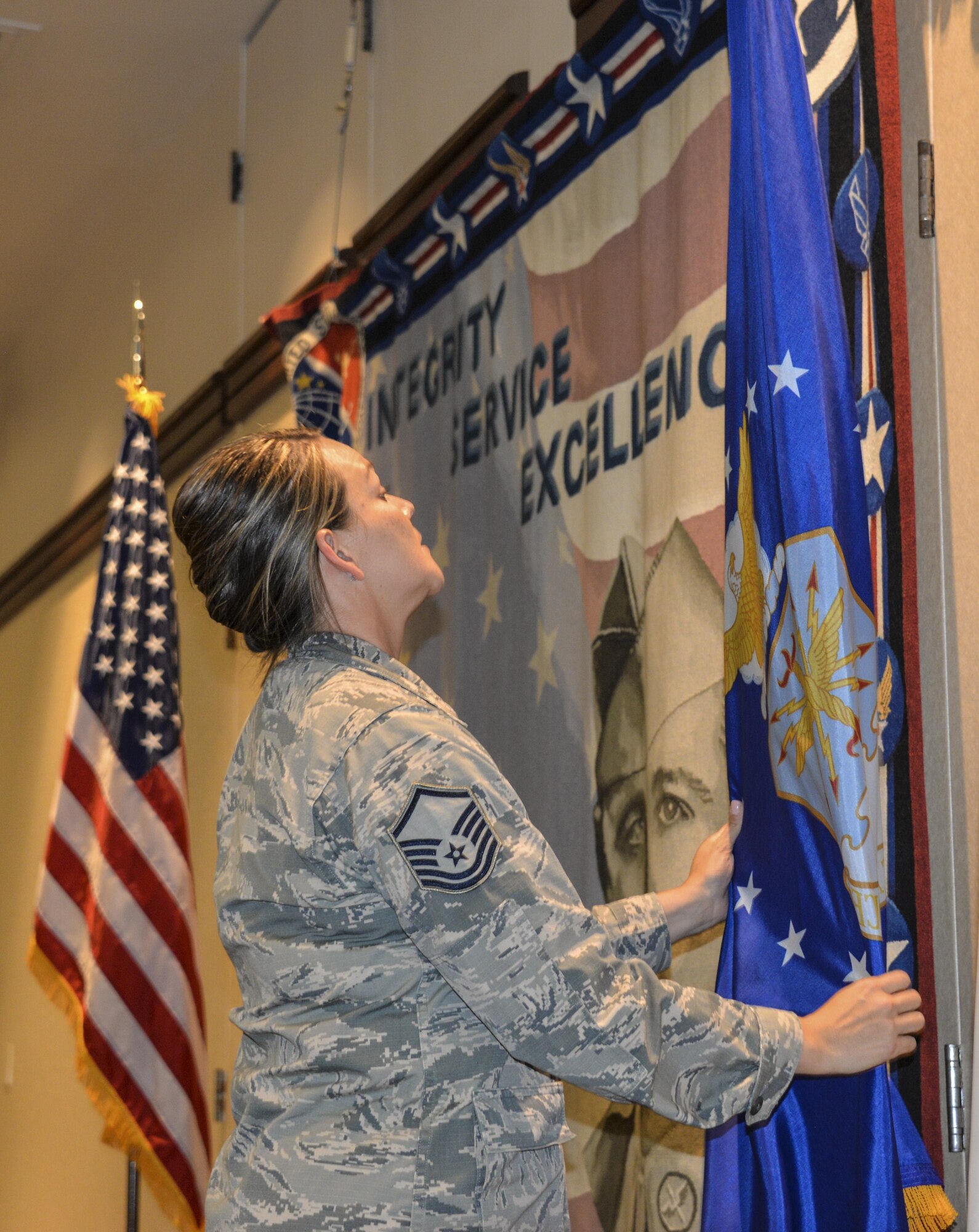 Master Sgt. Robin Debaghy, 60th Air Mobility Wing superintendent of protocol, makes sure the flags are positioned correctly for an Air Force event Aug. 25 at Travis Air Force Base, California. Details such as flag placement, where each person should sit at a table and little-known requirements are taken care of by Protocol specialists to ensure events are following proper protocol. 