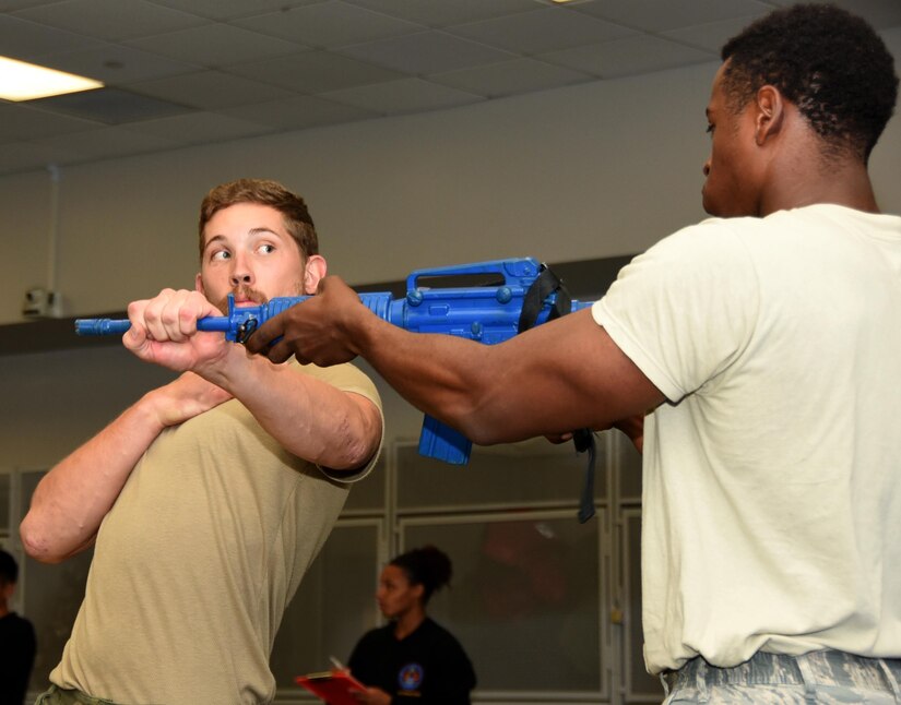 Capt. Karl Otto Kristoffersen, left, with the Royal Norwegian Air Force, practices weapons take-away techniques with a fellow Raven student at the United States Air Force Expeditionary Operation School on Joint Base McGuire-Dix-Lakehurst, New Jersey, Aug. 23. Phoenix Raven course students are trained on realistic practical exercises in antiterrorism, force protection, weapon system security, verbal judo, combatives, tactical baton employment and advanced firearms proficiency. (U.S. Air Force photo by Tech. Sgt. Jamie Powell)