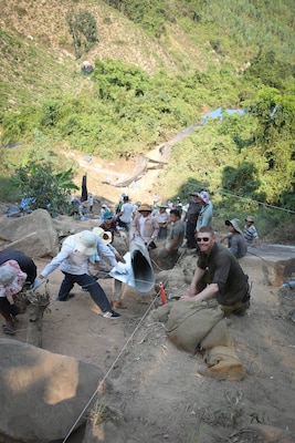 District archaeologist Jeremy Decker (right) working at the excavation site on the side of a steep mountain. 