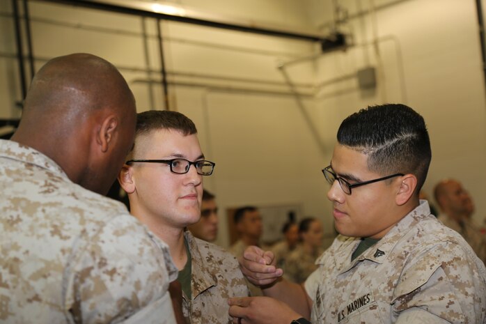 Lance Cpl. Jacob Beasley standing before a 9th Marine Corps District Headquarters formation Sept. 1, 2016, as he’s promoted and pinned on his chevrons by Cpl. Pablo Zacari and Sgt. Zachary Bryant. (U.S. Marine Corps Combat Camera photo by Cpl. Zachery Martin/Released)