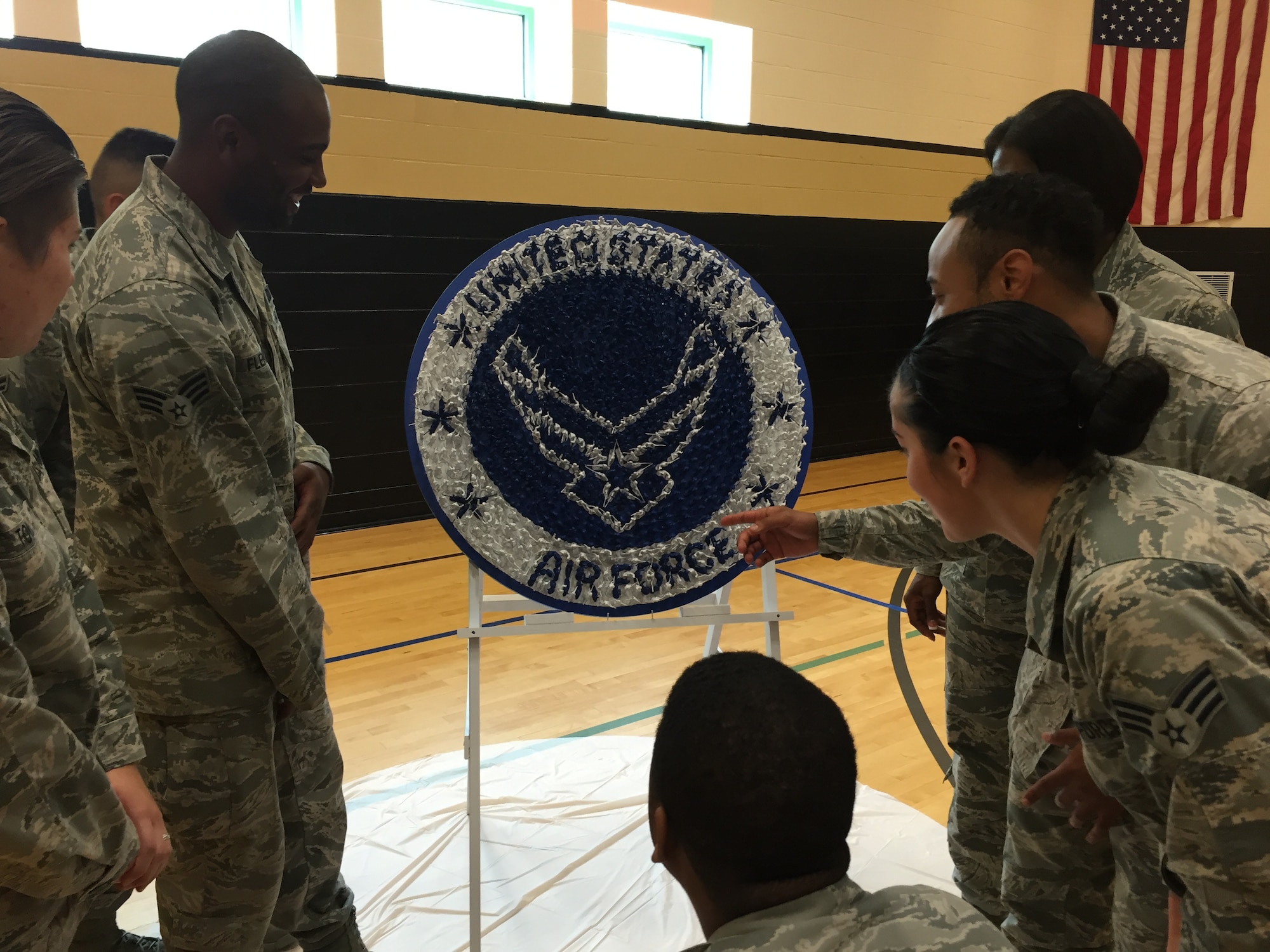 Airmen involved with the Justice Mentoring Program enjoy trying to count the number of plastic toy figures comprising the Air Force symbol. The token of appreciation for their mentoring efforts was presented on Aug. 24 in New Lebanon. (Skywrighter photos/Amy Rollins) 