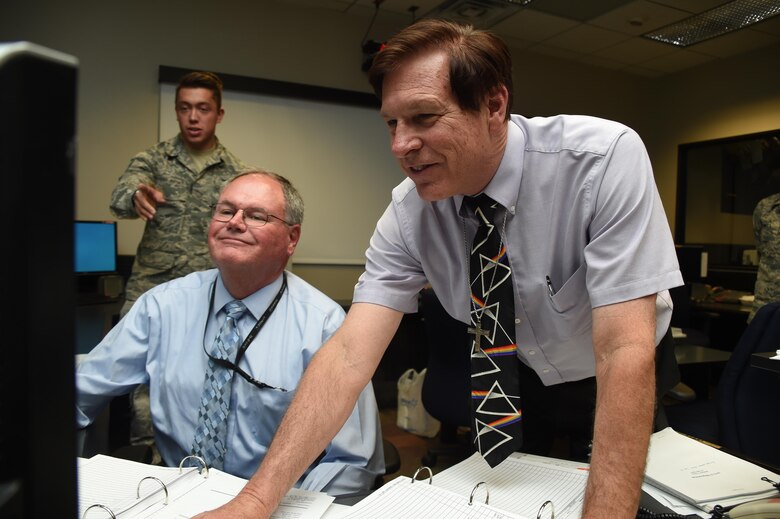 Bruce Carlson (right), Boeing technical advisor, and Mike O’Brine (center), Aerospace Corporation, send the final command to dispose of Global Positioning System Satellite Vehicle Number 23 at Schriever Air Force Base, Colorado, Friday, Aug. 26, 2016. Both of them were on the operations floor November 1990, when the satellite initially launched and when the solar array stopped working. They, along with the operators working, saved the satellite by tweaking its operating mode, and extended its life to 25 years. (U.S. Air Force photo/2nd Lt. Darren Domingo)