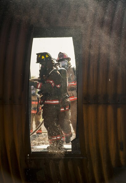 5th Civil Engineer Squadron firemen enter a burning B-52 trainer during an exercise at Minot Air Force Base, N.D., Sept. 1, 2016. For the exercise, teams of two went inside the trainer to put out the fire. (U.S. Air Force photo/Airman 1st Class Christian Sullivan)