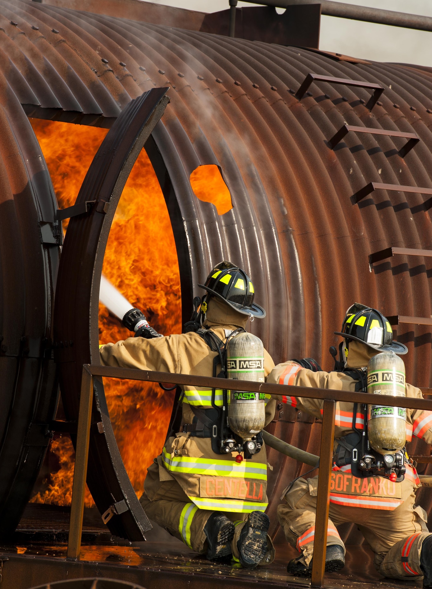 5th Civil Engineer Squadron firemen prepare to put out a fire on a B-52 trainer at Minot Air Force Base, N.D., Sept. 1, 2016. For the exercise, teams of two went inside the trainer to put out the fire. (U.S. Air Force photo/Airman 1st Class Christian Sullivan)