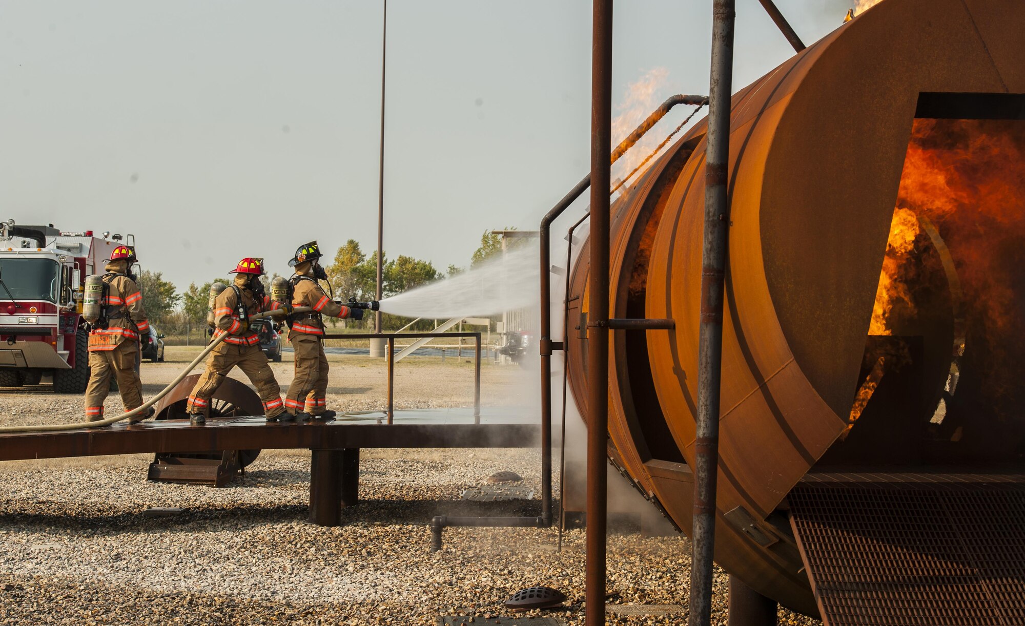 5th Engineer Squadron firefighters spray down an enflamed fire trainer at Minot Air Force Base, N.D., Sept. 1, 2016. The fire protection flight’s goal is to protect people, property and the environment from fires and disasters by providing fire prevention, firefighting, rescue and hazardous material response. (U.S. Air Force photo/Airman 1st Class Christian Sullivan)