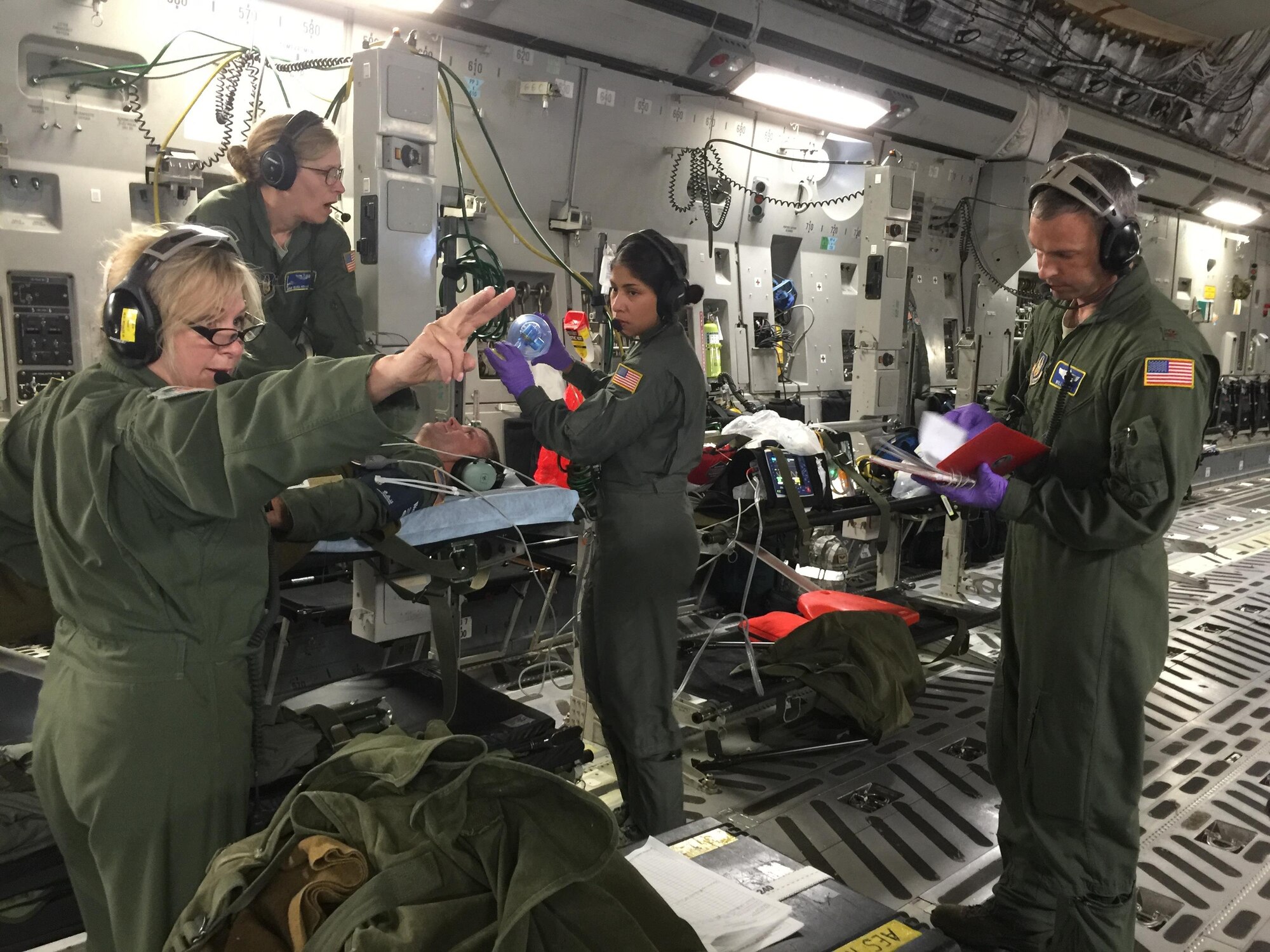 Lt. Col. Lorie O’Daniel, 446th Aeromedical Evacuation Squadron deputy officer-in-charge of commander support services and instructor flight nurse directs medical response to a simulated cardiac arrest situation. Col. Sean Pierce, 446th Operations Group commander, served as a simulated patient during one of the training sessions during the flight. (Photo by Maj. Brooke Cortez)