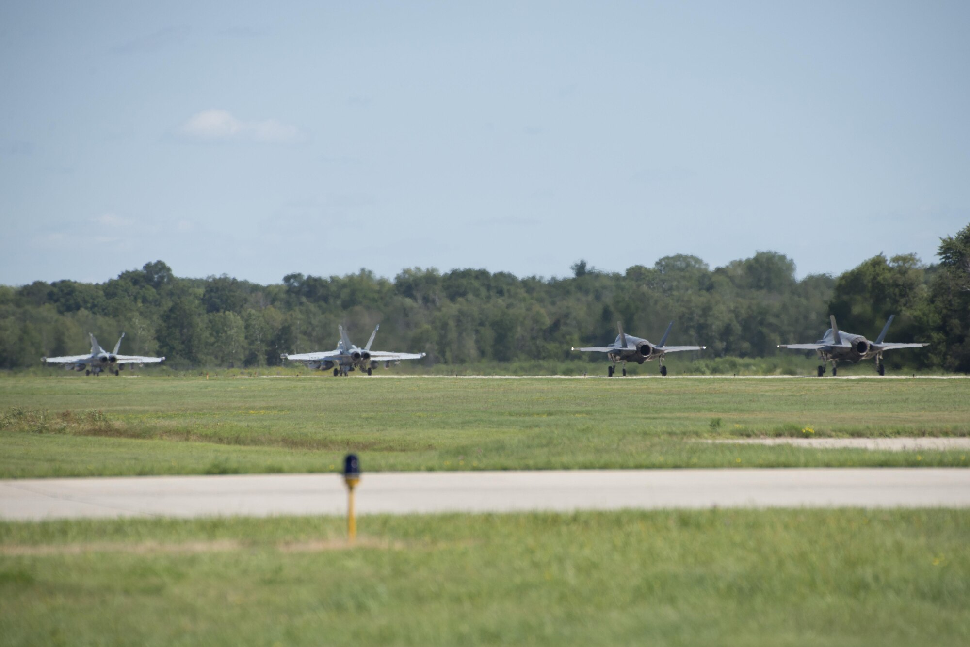 132nd Electronic Attack Squadron EA-18 Growlers and 33rd Fighter Wing F-35As taxi down the flightline during Northern Lightning Aug. 22, 2016, at Volk Field, Wis. Northern Lightning is a tactical-level, joint training exercise that emphasizes fifth and fourth generation assets engaged in a contested, degraded environment. (U.S. Air Force photo by Senior Airman Stormy Archer)