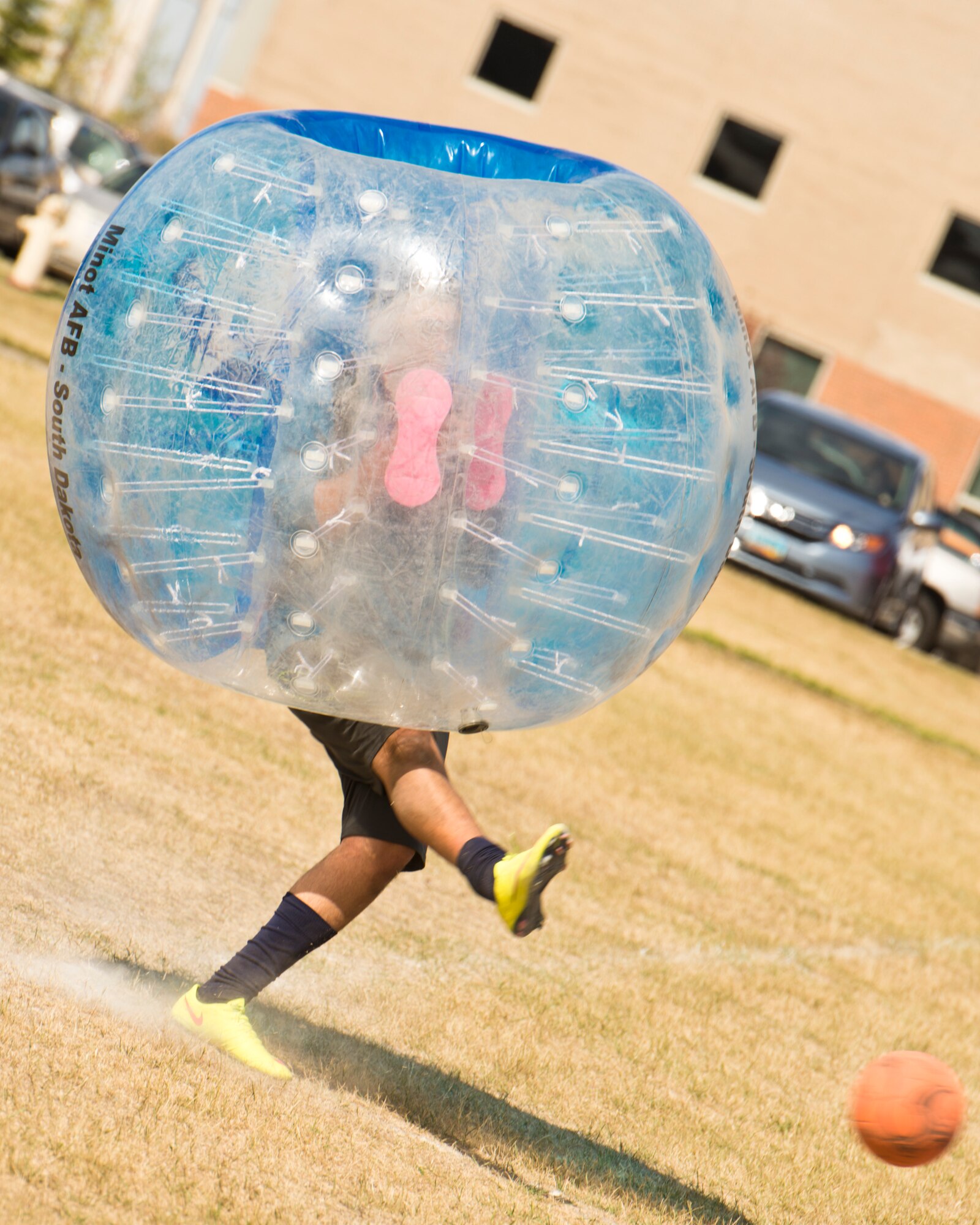A Team Minot Airman kicks a soccer ball while playing knockerball during the Summer Games at Minot Air Force Base, N.D., Aug. 30, 2016. In knockerball, a variation of soccer, participants wear large inflatable bubbles around their upper body that allows them to bounce off other players, and makes falling down a bit more fun. (U.S. Air Force photo/Airman 1st Class J.T. Armstrong)