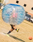 A Team Minot Airman kicks a soccer ball while playing knockerball during the Summer Games at Minot Air Force Base, N.D., Aug. 30, 2016. In knockerball, a variation of soccer, participants wear large inflatable bubbles around their upper body that allows them to bounce off other players, and makes falling down a bit more fun. (U.S. Air Force photo/Airman 1st Class J.T. Armstrong)