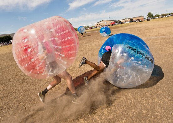 A Team Minot Airman falls while playing knockerball during the Summer Games at Minot Air Force Base, N.D., Aug. 30, 2016. In knockerball, a variation of soccer, participants wear large inflatable bubbles around their upper body that allows them to bounce off other players, and makes falling down a bit more fun. (U.S. Air Force photo/Airman 1st Class J.T. Armstrong)
