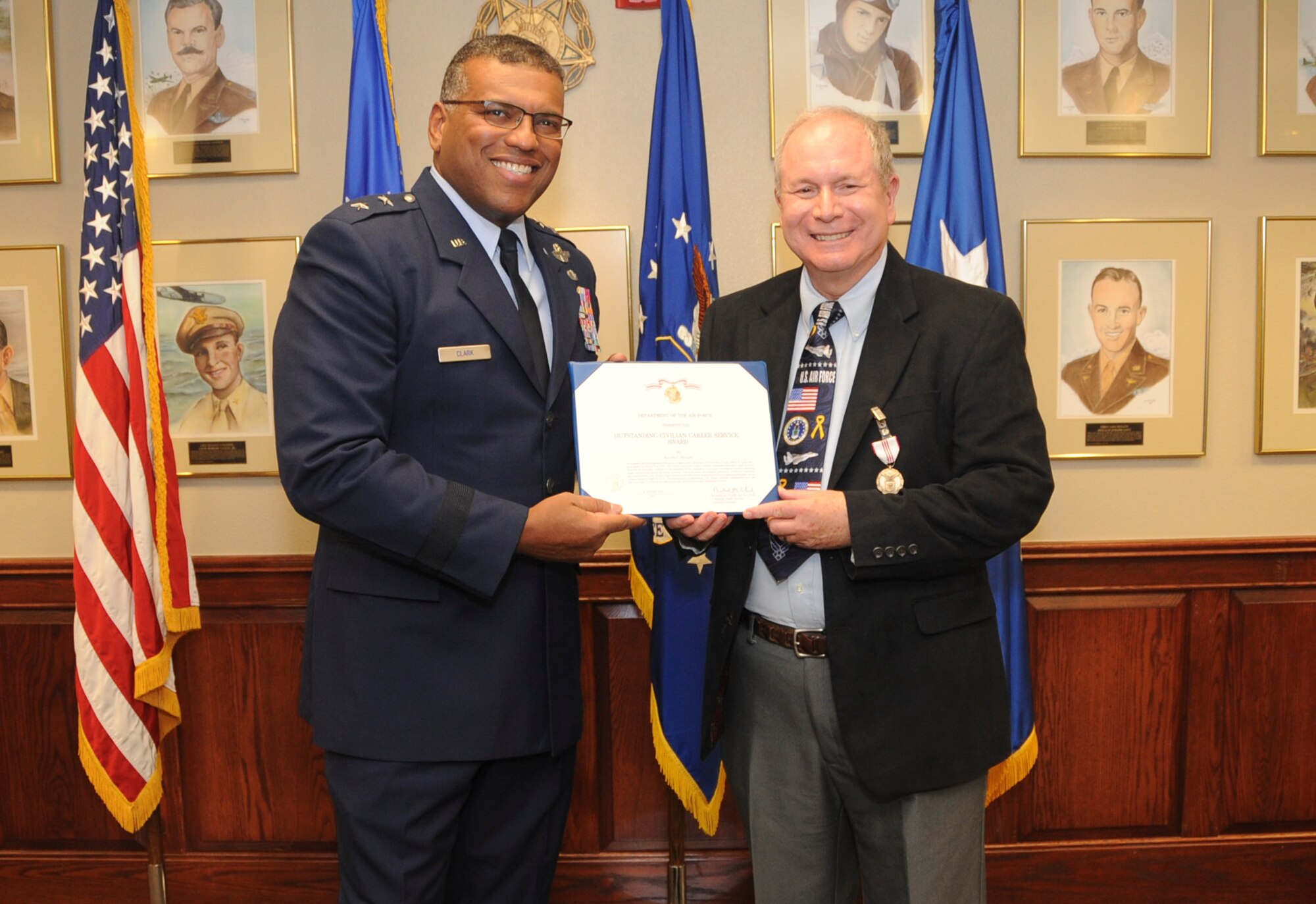 U.S. Maj. Gen. Richard M. Clark, Eighth Air Force commander, hands Ed Wempe, Eighth Air Force Intelligence Directorate technical director, the Outstanding Civilian Career Service Award during Wempe's retirement ceremony at Barksdale AFB, La., Aug. 18, 2016. For Wempe, the award signifies more than four decades of active duty and civil service within Intelligence career field. (U.S. photo by Amn Alexis Schultz)