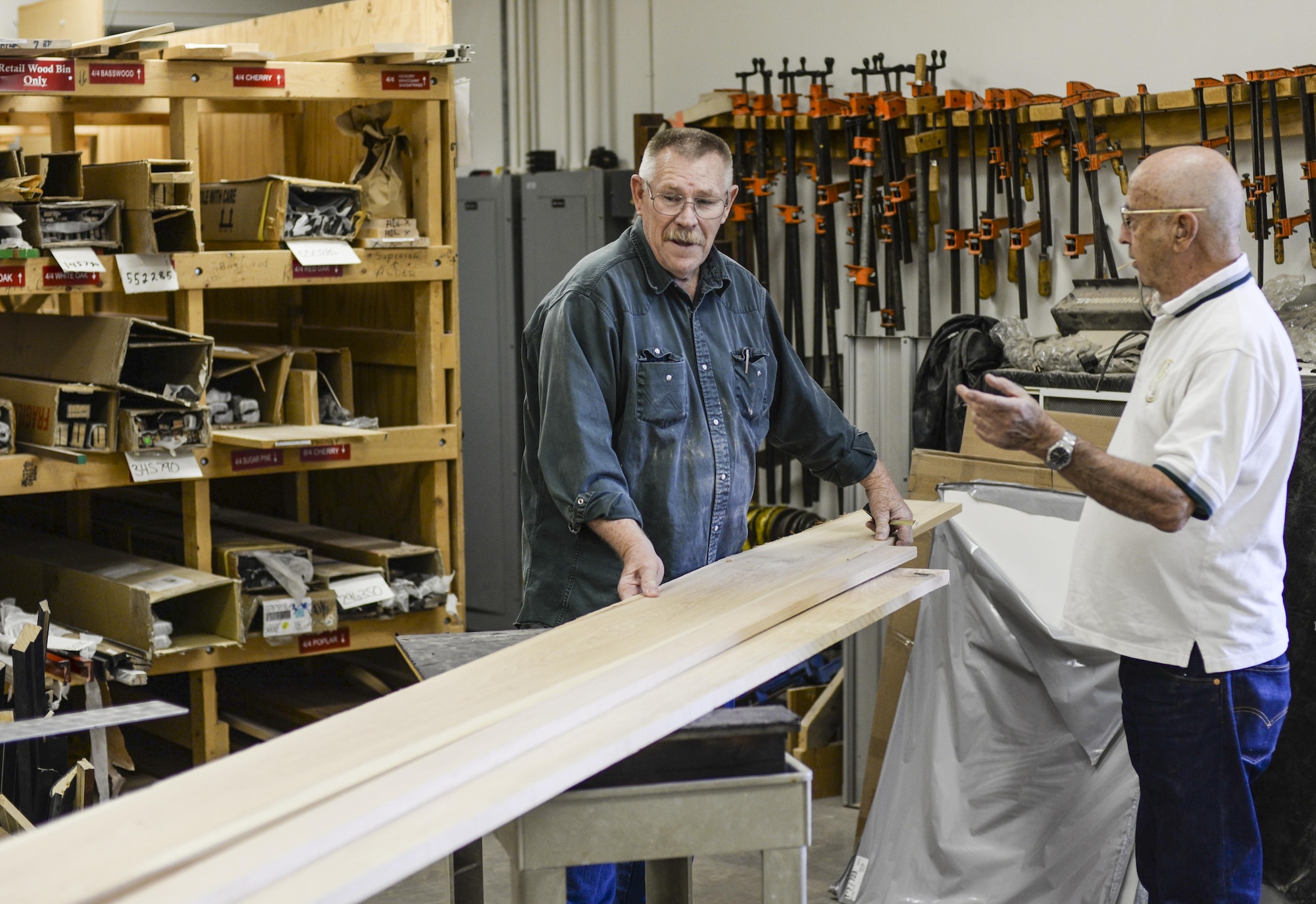 Joe, the 49th Force Support Squadron Wood Shop supervisor and Gary, a customer and retired Air Force Vietnam veteran, survey a board of redwood at Holloman Air Force Base, N.M. 23 Aug. 2016. The shop houses a variety of top-of-the-line woodworking equipment. (Last names are being withheld due to operational requirements. U.S. Air Force photo by Airman Alexis P. Docherty) 