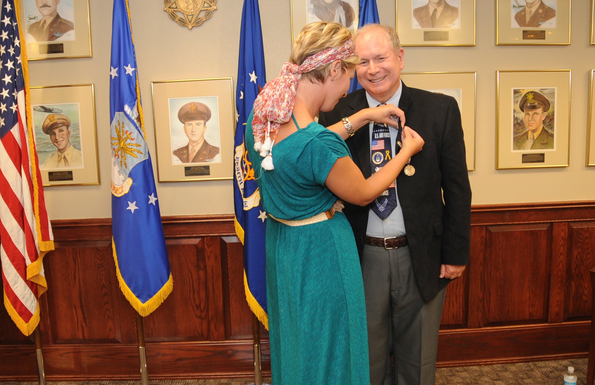 Ed Wempe, Eighth Air Force Intelligence Directorate technical director, receives a lapel pin from his daughter during a retirement ceremony at Barksdale Air Force Base, La., Aug. 18, 2016. Family, friends, colleagues and Air Force leadership joined Wempe to commemorate more than 45 years of service. (U.S. Air Force photo by Amn Alexis Schultz)