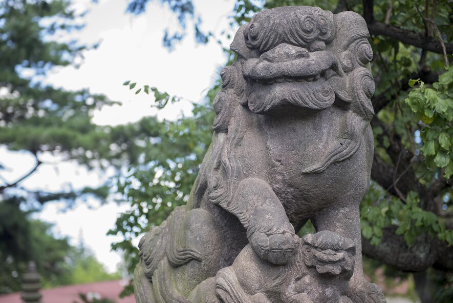 A komainu statue stands in front of the Yokota's Officer's Club at Yokota Air Base, Japan, Aug. 25, 2016. The statue is one of a matched pair that were donated to the base commemorating the friendship between base leadership and local community leaders. Komainu, also known as lion-dogs, are often found in front of shrines, gates or houses and are said to provide protection. (U.S. Air Force photo by Senior Airman David C. Danford/Released)