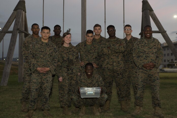 U.S. Marines with Marine Aircraft Group 12 Headquarters pose for a photo after running the obstacle course at Marine Corps Air Station Iwakuni, Japan, Aug. 26, 2016. The group emerged victorious in a team competition within their respective shop of maneuvering a bowl of water to the end of the obstacle course. (U.S. Marine Corps photo by Lance Cpl. Abrego) 