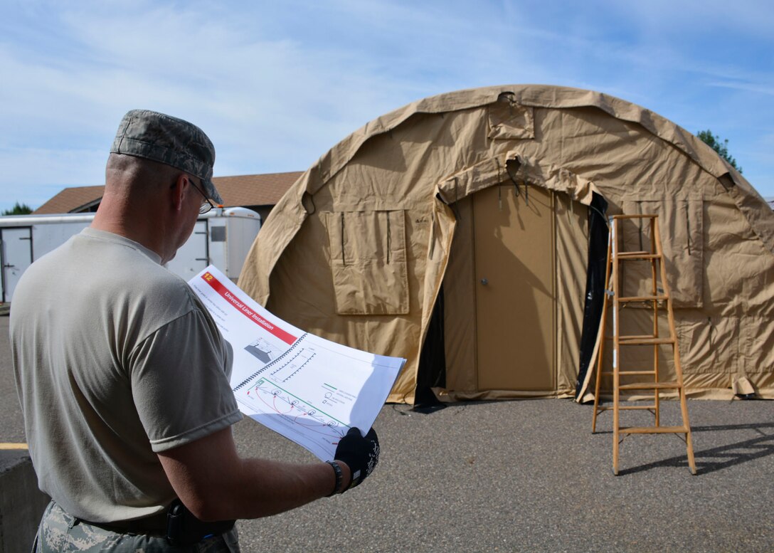 120th Sustainment Services Flight Management and Program Assistant Master Sgt. Troy Anderson reviews instructions while members of the 120th SSF construct an Alaska Small Shelter System during the guard drill at the 120th Airlift Wing in Great Falls, Mont. Aug. 13, 2016. (U.S. Air National Guard photo by Senior Master Sgt. Eric Peterson)