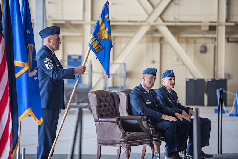 Command Chief Master Sgt. David Garganta, senior enlisted leader of the 176th Wing, Alaska Air National Guard, holds the unit guidon while Col. Blake Gettys and Col. Steven deMilliano sit during a change-of-command ceremony on Joint Base Elmendorf-Richardson, Alaska, July 12. Gettys, who served as the 176th Wing’s commander since 2014, relinquished control of the wing to deMilliano during the ceremony. (U.S. Air National Guard photo by Staff Sgt. Edward Eagerton/released)