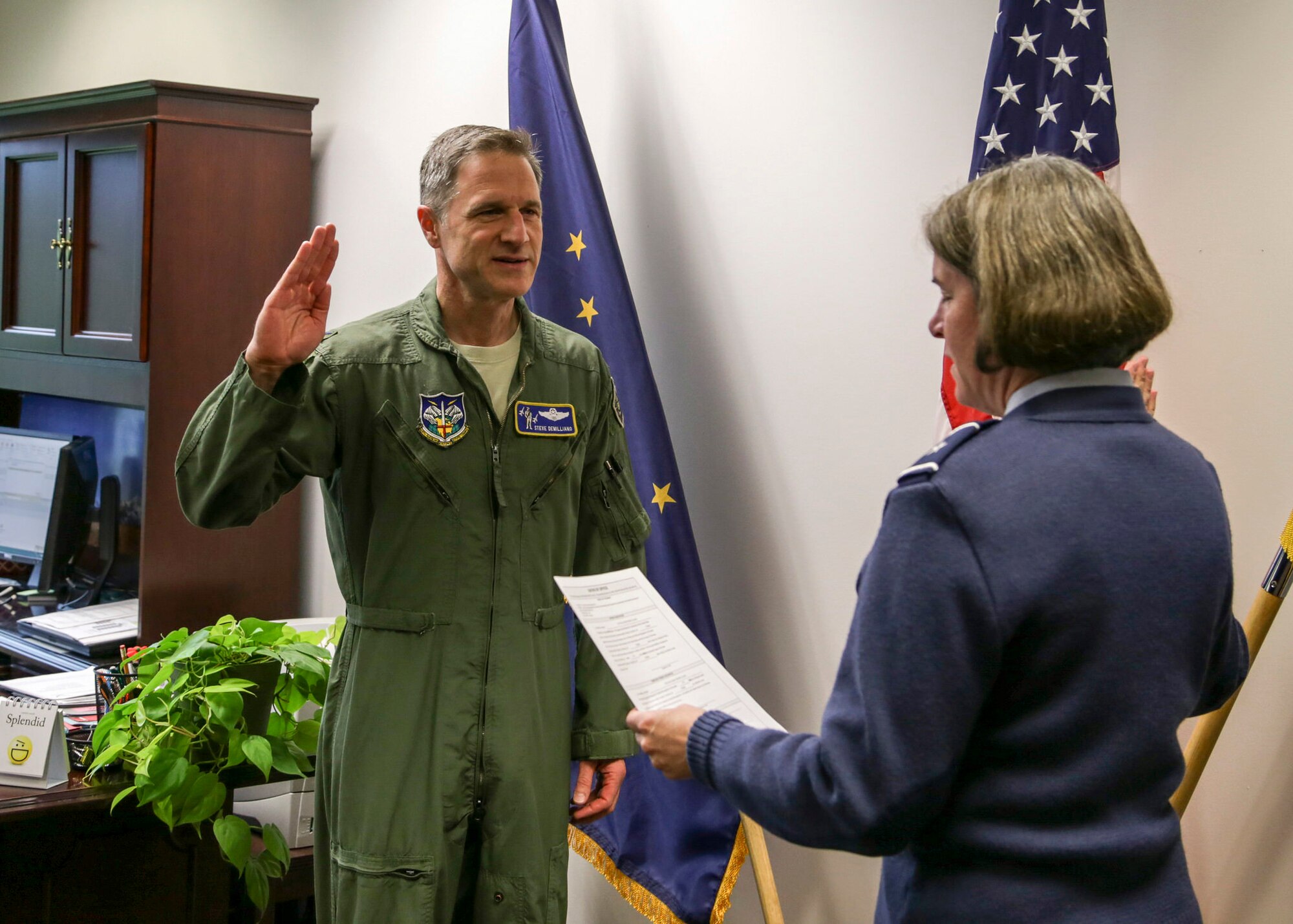 Brig. Gen. Karen Mansfield, Alaska Air National Guard commander, administers the oath of office to Col. Steven deMilliano, 176th Wing incoming commander, during a ceremony at the National Guard Armory on Joint Base Elmendorf-Richardson, July 11, 2016. (U.S. Army photo by Staff Sgt. Balinda O’Neal Dresel)