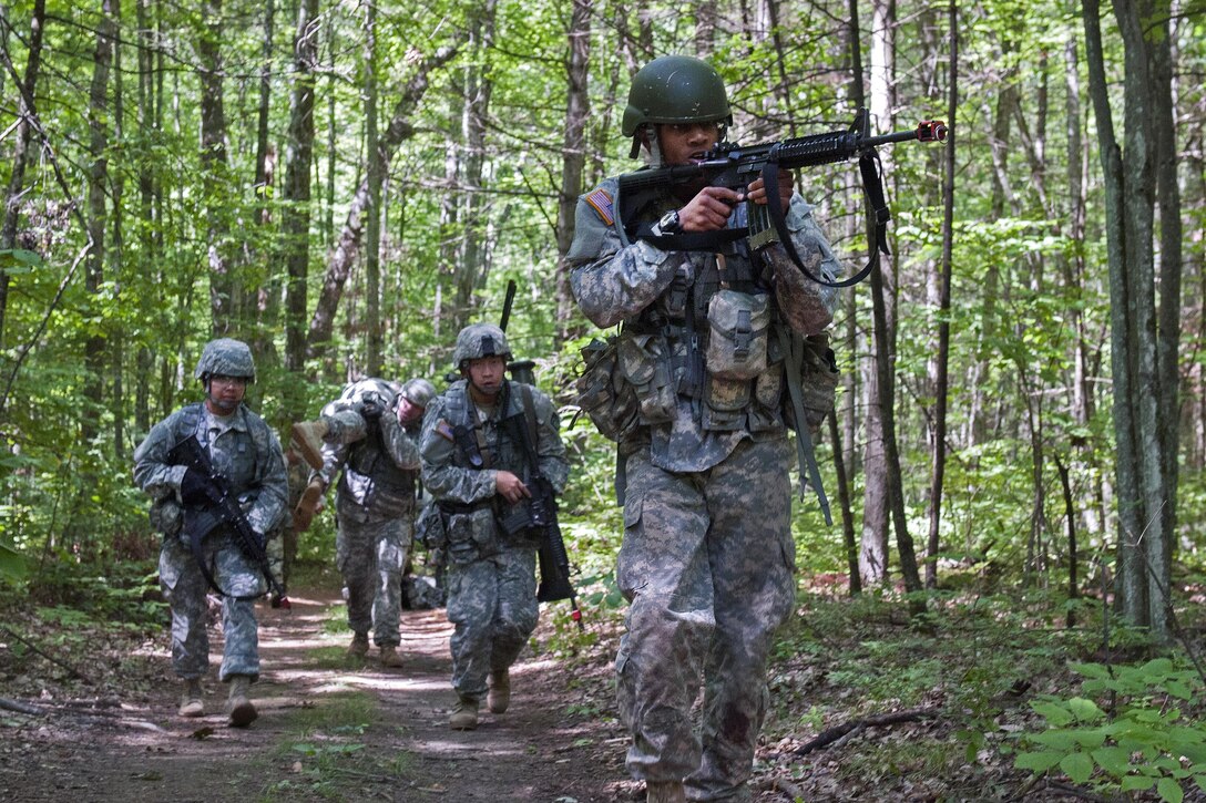 Soldiers provide security while a team member carries a role-playing casualty to their next object during training at Camp Johnson, Colchester, Vt., Aug. 23, 2016. Army National Guard photo by Spc. Avery Cunningham