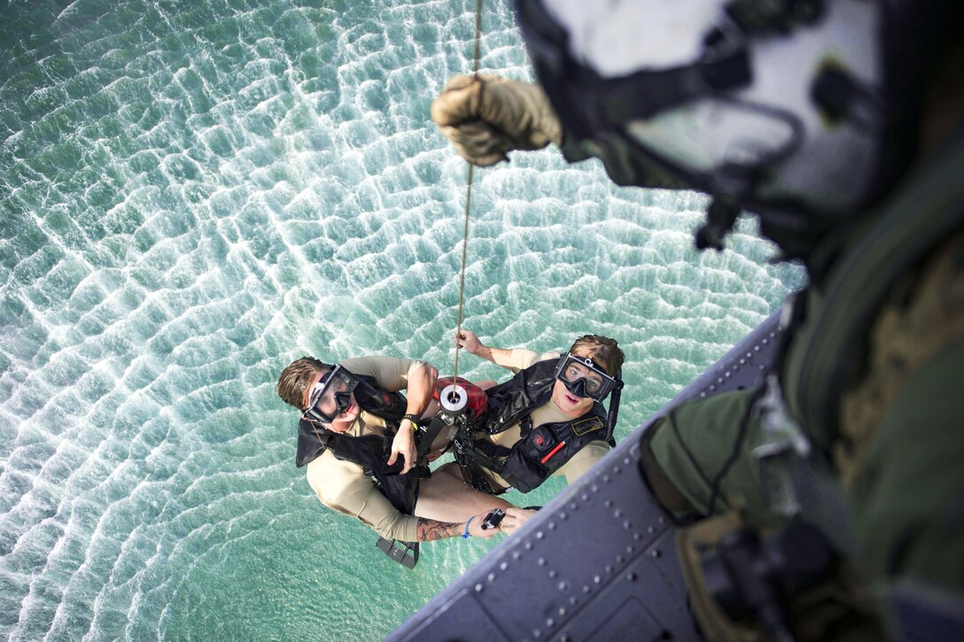 An MH-60S Seahawk helicopter hoists Navy Petty Officer 2nd Class Ben McCracken, left, and Petty Officer 3rd Class Sean Magee from the water during a Pacific Partnership 2016 search and rescue drill in Padang, Indonesia, Aug. 29, 2016. McCracken and Magee are naval air crewman helicopter assigned to Helicopter Sea Combat Squadron 21. During the drill, aviation rescue swimmers hoisted simulated casualties into a helicopter to transport to the hospital ship USNS Mercy. Navy photo by Petty Officer 3rd Class Trevor Kohlrus