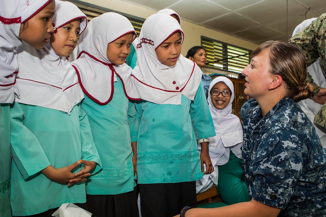 Navy Petty Officer 3rd Class Emily Cates talks with students from a primary school during an expert exchange at a health clinic as part of Pacific Partnership 2016 in Padang, Indonesia, Aug. 26, 2016. Medical personnel from the hospital ship USNS Mercy discussed health information with field experts and students. This is the fifth time Pacific Partnership has visited Indonesia. Australian Air Force photo by Spec. Cpl. David Cotton