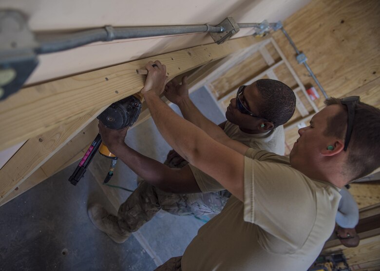 Staff Sgt. Donald Scott (back) and Senior Airman Eric Woolston (front), 455th Expeditionary Civil Engineer Squadron structural journeyman and craftsman, install shelves in a new Airman’s Ministry Center, Bagram Airfield, Afghanistan, Aug. 31, 2016. The structures team paired with the ECES electricians to renovate and provide electricity to the new building. (U.S. Air Force photo by Senior Airman Justyn M. Freeman)