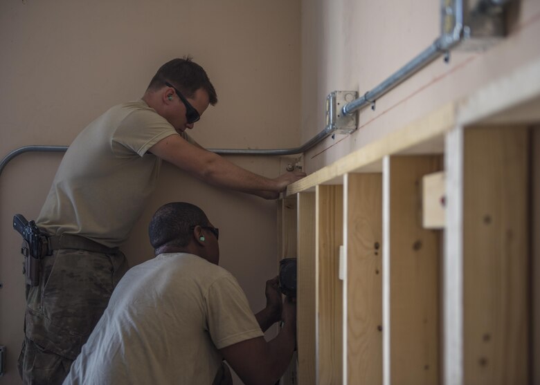 Staff Sgt. Donald Scott (front) and Senior Airman Eric Woolston (back), 455th Expeditionary Civil Engineer Squadron structural journeyman and craftsman, install shelves in a new Airman’s Ministry Center, Bagram Airfield, Afghanistan, Aug. 31, 2016. The structures team paired with the ECES electricians to renovate and provide electricity to the new building. (U.S. Air Force photo by Senior Airman Justyn M. Freeman)