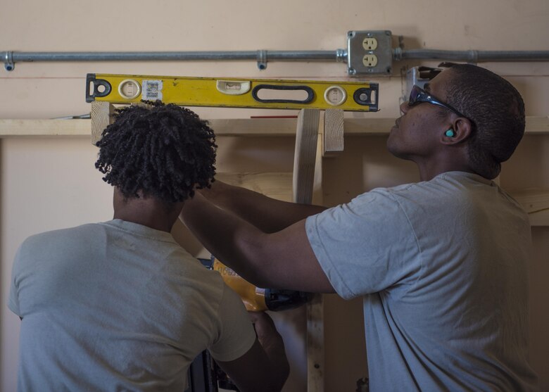 Staff Sgt. Donald Scott (right) and Airman 1st Class Taylor Davis (left), 455th Expeditionary Civil Engineer Squadron, aligns wood using a level, Bagram Airfield, Afghanistan, Aug. 31, 2016. The structures team fitted shelves in a newly renovated Airman’s Attic and ministry center. (U.S. Air Force photo by Senior Airman Justyn M. Freeman)