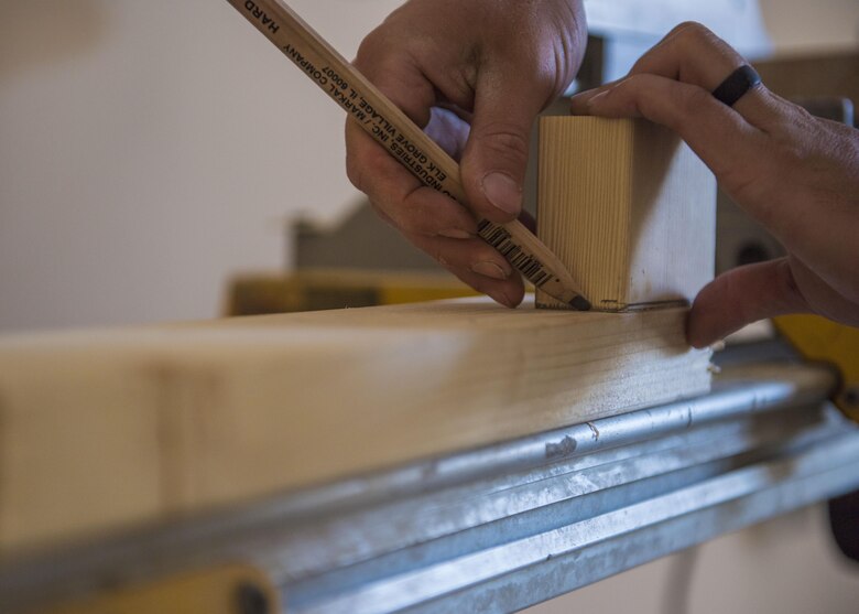 Airman 1st Class Taylor Davis, 455th Expeditionary Civil Engineer Squadron structural journeyman, measures wood, Bagram Airfield, Afghanistan, Aug. 31, 2016. The ECES structures and electrical units supplied shelving units and electricity to a newly renovated ministry center and Airman’s Attic. (U.S. Air Force photo by Senior Airman Justyn M. Freeman)
