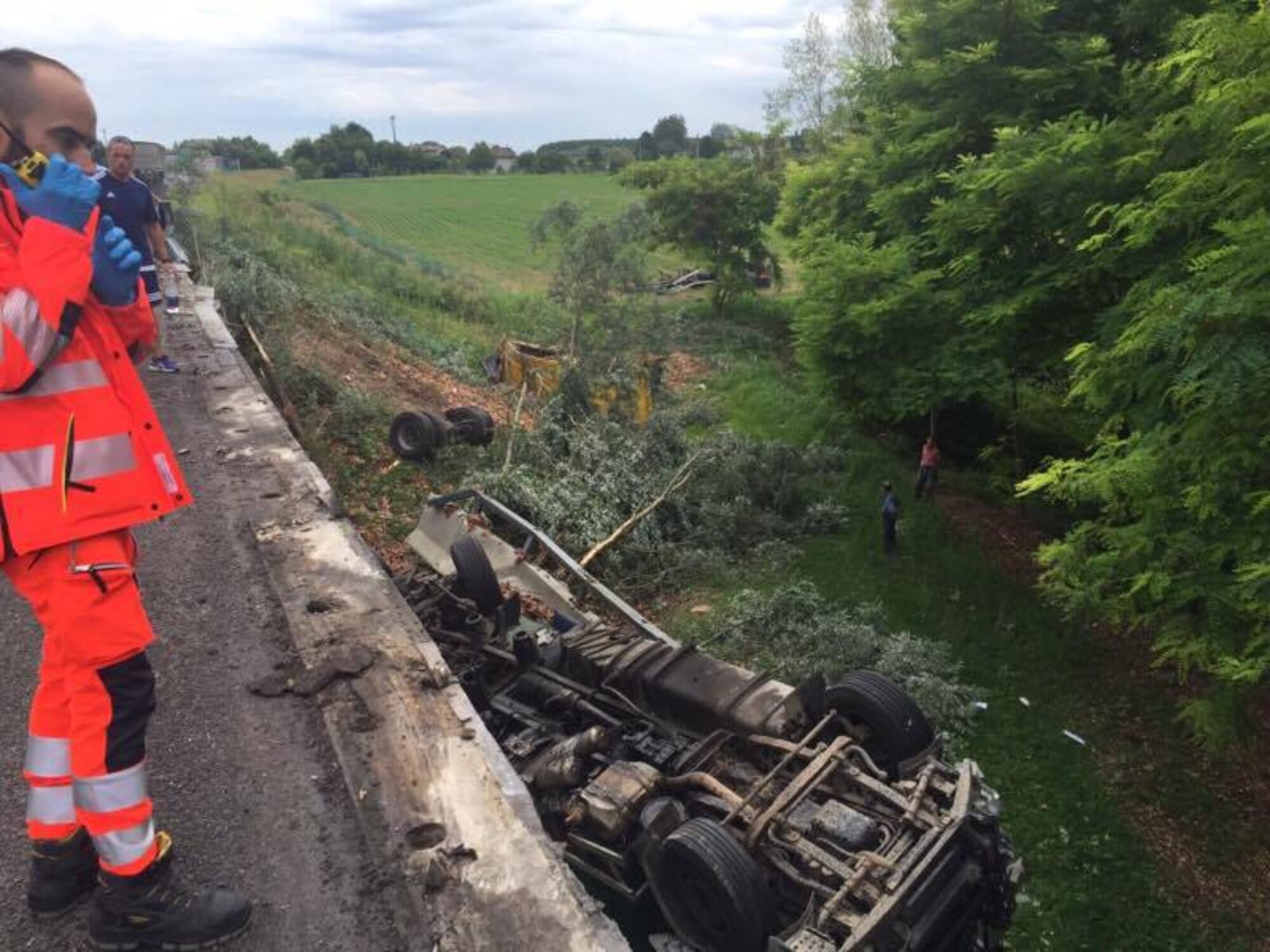 Paul Enrico Gheorghe, a resident of Roveredo in Piano, Italy, overturned truck and trailer sits at the bottom of a bridge after its tire blew and crashed July 28, 2016. Staff Sgt. Christopher Chaves, 31st Civil Engineer Squadron firefighter, was returning from the Venice airport when the accident unfolded right in front of him. Chaves applied a tourniquet and splint the driver’s leg on scene. (Courtesy photo)