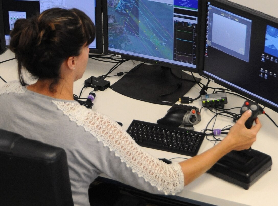 DAHLGREN, Va. - Laura San Filippo, a Navy Scan Eagle unmanned aerial vehicle operator, conducts over-the-horizon contact detection, tracking, and identification while monitoring for hostile intent at the 2016 USS Dahlgren demonstration, Aug. 30. The Scan Eagle was part of the Navy's evaluation of a strike group's gun weapon systems, combat systems, and unmanned vehicles integrated with surface and air assets. The test - made possible by a cybernetic laboratory called USS Dahlgren - proved engagement coordination across the battlegroup and live fire destruction of multiple targets from two combatants utilizing two different gun based systems. 
