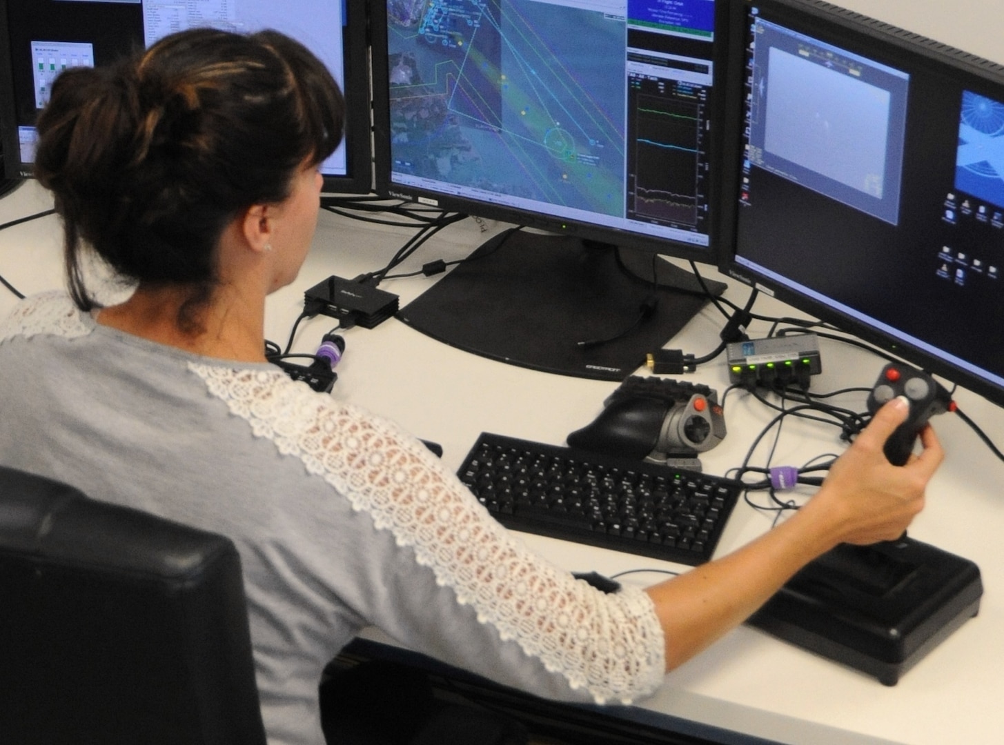 DAHLGREN, Va. - Laura San Filippo, a Navy Scan Eagle unmanned aerial vehicle operator, conducts over-the-horizon contact detection, tracking, and identification while monitoring for hostile intent at the 2016 USS Dahlgren demonstration, Aug. 30. The Scan Eagle was part of the Navy's evaluation of a strike group's gun weapon systems, combat systems, and unmanned vehicles integrated with surface and air assets. The test - made possible by a cybernetic laboratory called USS Dahlgren - proved engagement coordination across the battlegroup and live fire destruction of multiple targets from two combatants utilizing two different gun based systems. 