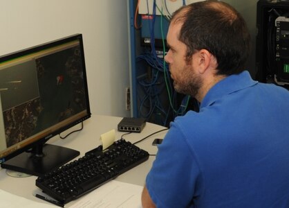 DAHLGREN, Va. - Navy engineer Kevin Murray operates the Visual Automated Scoring System (VASS) terminal at the 2016 USS Dahlgren demonstration, Aug. 30. VASS was vital to the Navy's evaluation of a strike group's gun weapon systems, combat systems, and unmanned vehicles integrated with surface and air assets. VASS calculates gunfire miss distances and instantly adjusts targeting for gunners to converge gunfire onto a target without risking the lives of forward observers. The cybernetic laboratory known as USS Dahlgren proved engagement coordination across the battlegroup and live fire destruction of multiple targets from two combatants utilizing two different gun based systems.