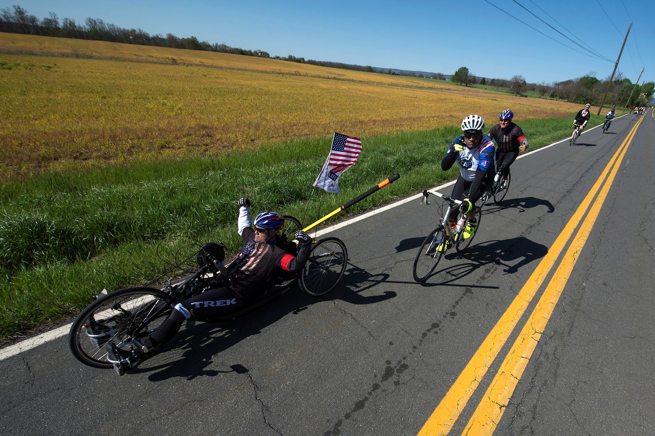 Medically retired Navy Petty Officer 1st Class Jerry W. Padgett II, front, raises his arms during the Face of America bike route in Gettysburg, Pa., April 24, 2016. More than 150 disabled veteran cyclists were paired among 600 able-bodied cyclists to ride 110 miles from Arlington, Va. to Gettysburg, Pa., over two days in honor of veterans and military members. DoD photo by EJ Hersom
