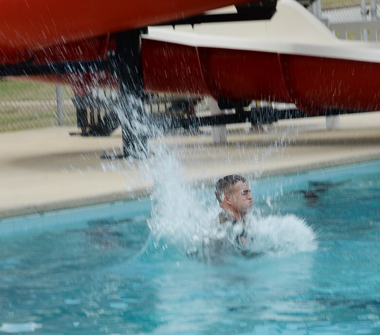 Lance Cpl. Jared Armstrong, administration specialist, Military Personnel, Marine Corps Logistics Base Albany, conducts the abandon ship drill off the high-dive platform and into the Base Pool as part of the annual swim qualification aboard Marine Corps Logistics Base Albany, Aug 24.
