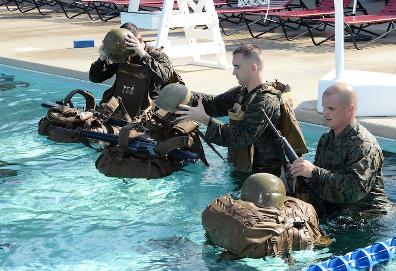 Marines prepare to use their packs as a floating device during their annual swim qualification at the Base Pool aboard Marine Corps Logistics Base Albany, Aug 24.