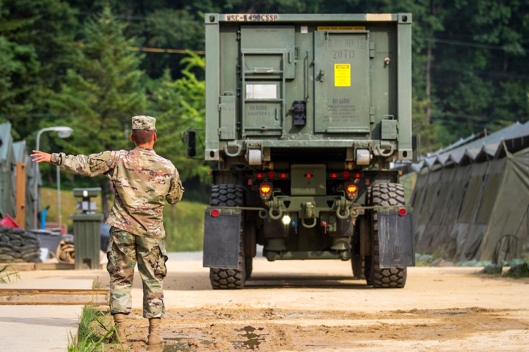 Army Pfc. Andrew Skalecki uses hand signals to direct Army Spc. Jose Rodriquez as he operates a truck carrying 2,000 gallons of water during Exercise Ulchi Freedom Guardian 2016 at Yongin, South Korea, Aug 25, 2016. Skalecki and Rodriquez are water treatment specialist assigned to the 339th Quartermaster Company. Army photo by Staff Sgt. Ken Scar