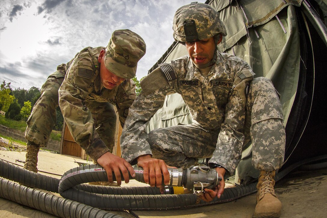Army Pfc. Andrew Skalecki, left, and Army Spc. Jose Rodriquez connect hoses to resupply water for over 500 U.S., South Korean and Canadian soldiers participating in Exercise Ulchi Freedom Guardian 2016 at Yongin, South Korea, Aug 25, 2016. Skalecki and Rodriquez are water treatment specialist assigned to the 339th Quartermaster Company. Army photo by Staff Sgt. Ken Scar