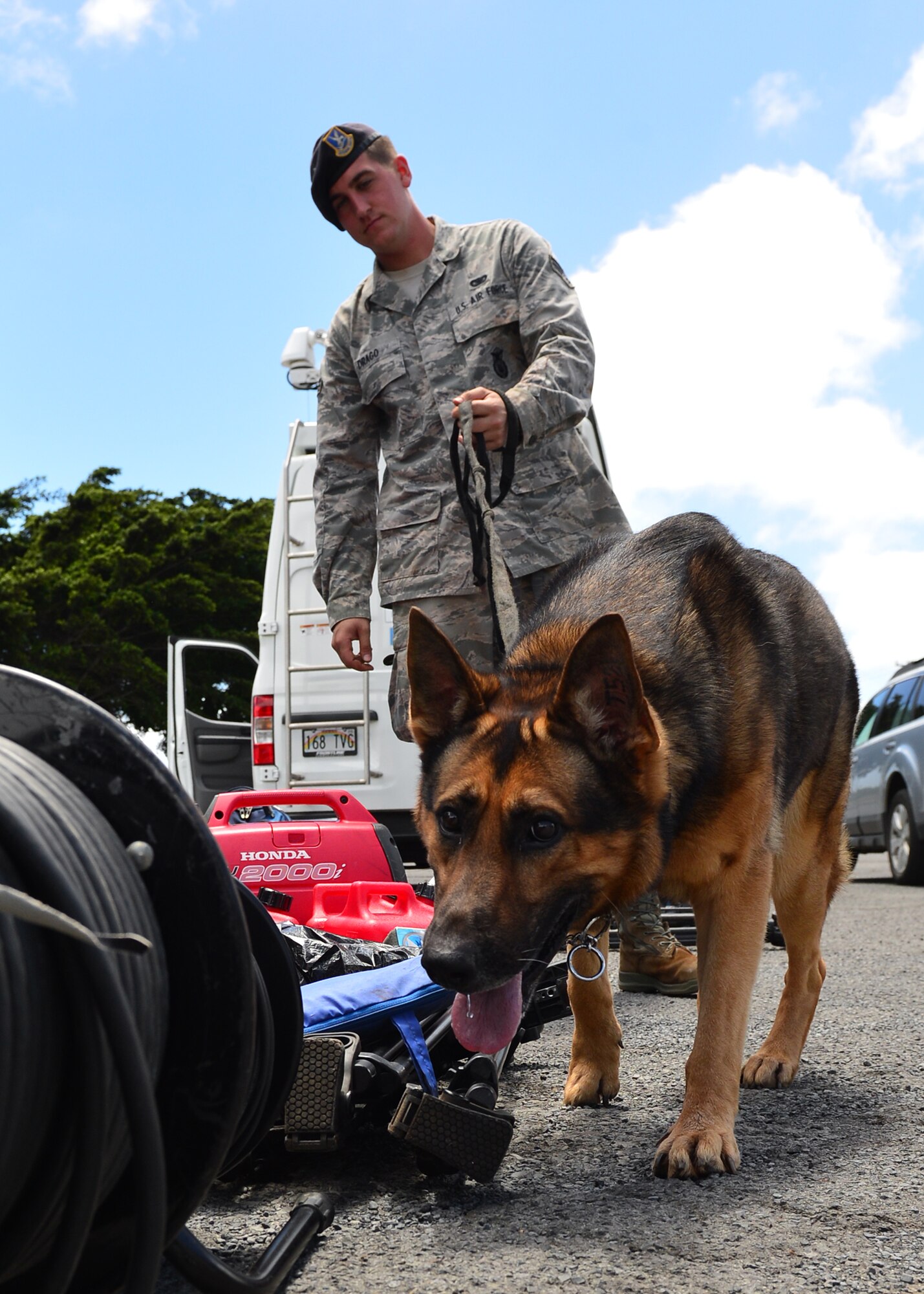 Senior Airman Joseph Drago, 647th Security Forces Squadron military working dog handler, and Dollar, 647th Security Forces Squadron military working dog, conduct an inspection of broadcast equipment on Joint Base Pearl Harbor-Hickam, Hawaii, Aug. 31, 2016. President Barack Obama was in Hawaii to speak at the Pacific Island Conference of Leaders and the International Union for Conservation of Nature World Conservation Congress. (U.S. Air Force Photo by Tech. Sgt. Aaron Oelrich/Released) 