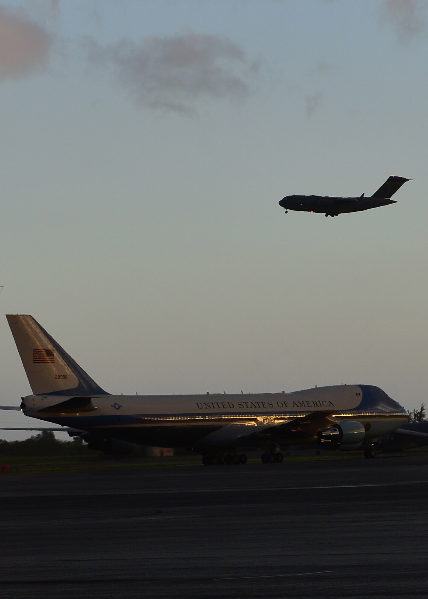 A C-17 Globemaster III from the 535th Airlift Squadron prepares to land as a VC-25A, Air Force One, taxis on Joint Base Pearl Harbor-Hickam, Hawaii, Aug. 31, 2016. President Obama was in Hawaii to speak at the Pacific Island Conference of Leaders and the International Union for Conservation of Nature World Conservation Congress. (U.S. Air Force Photo by Tech. Sgt. Aaron Oelrich/Released) 